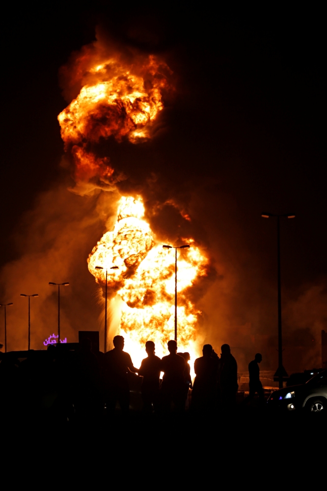 Emergency and rescue personnel are seen blocking the road leading to a fire in an oil pipeline in Buri village, south of Manama, Bahrain November 11, 2017. REUTERS/Hamad I Mohammed