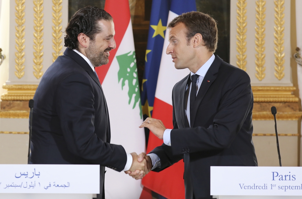 FILE - In this Sept. 1 2017 file photo, French President Emmanuel Macron, right, shakes hands with Lebanese Prime Minister Saad Hariri during a joint press conference at the Elysee Palace in Paris. Hariri has accepted an invitation to come to France after his surprise resignation from Saudi Arabia nearly two weeks ago that stunned Lebanon and rattled the region, the French president's office announced Thursday Nov. 16, 2017. (Ludovic Marin, Pool via AP, File)