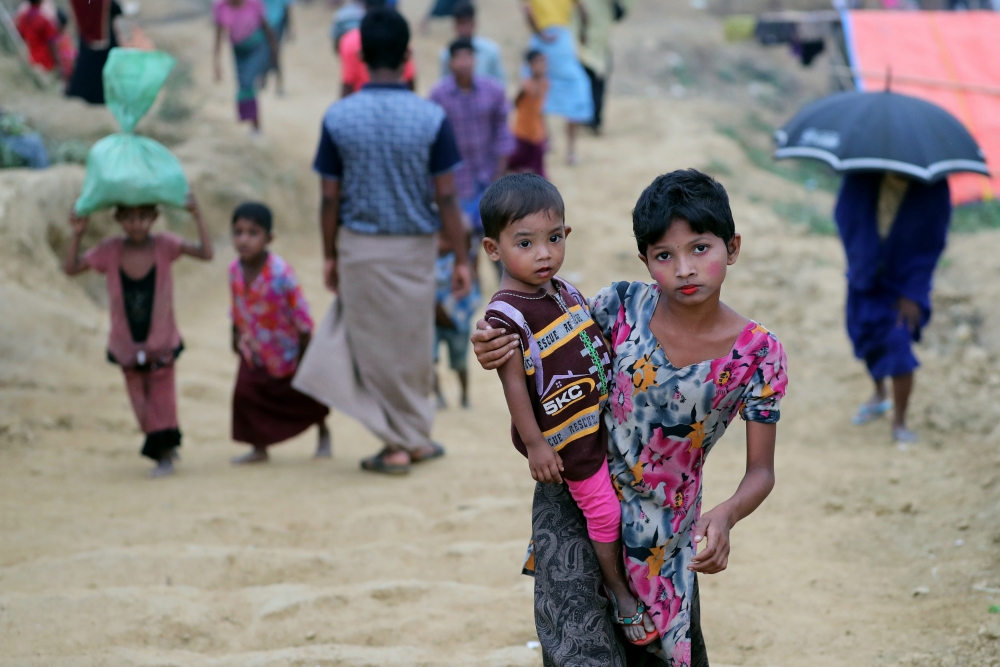 A Rohingya refugee girl carries a child in the Palong Khali refugee camp in Cox's Bazar, Bangladesh, November 17, 2017. REUTERS/Mohammad Ponir Hossain