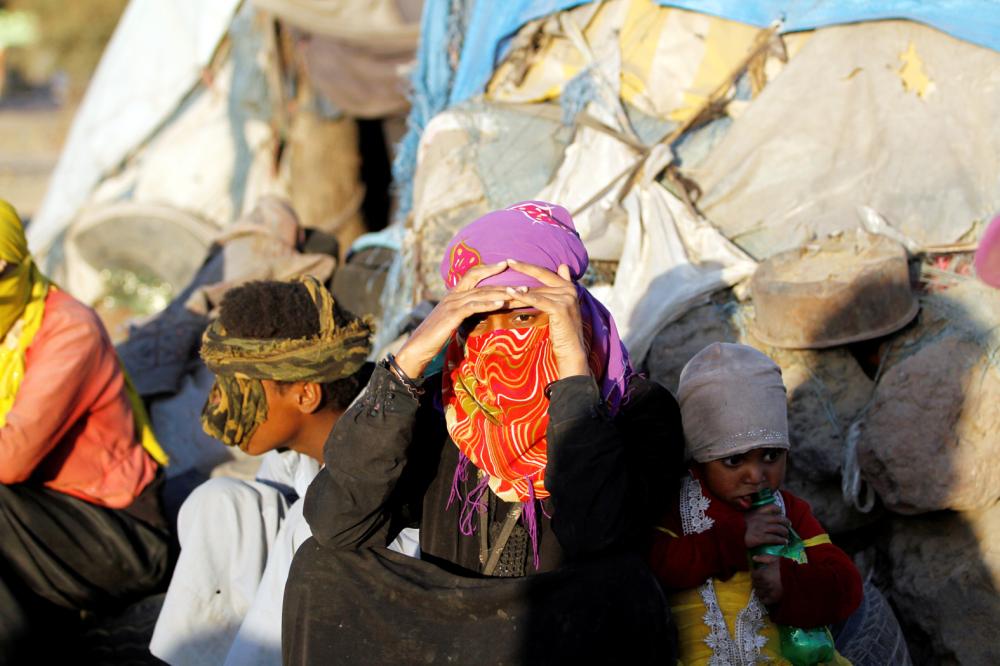 



عائلة يمنية أمام مخيم للنازحين، بعد أن أجبرتها الميليشيات على ترك منزلها في صنعاء.  (رويترز)