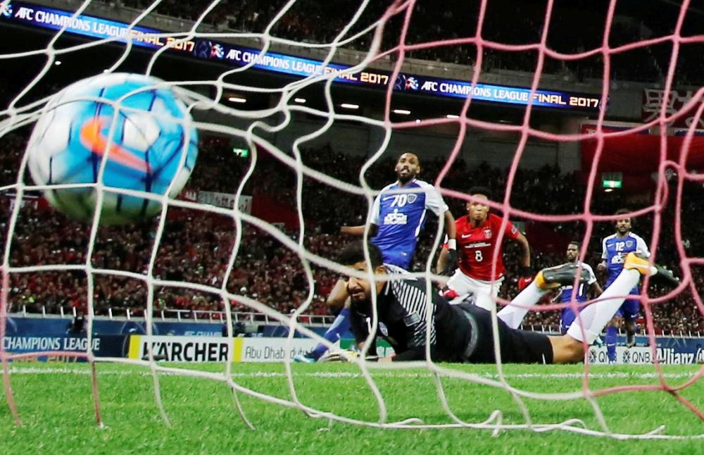 Soccer Football - Japan's Urawa Red Diamonds v Saudi Arabia's Al Hilal - AFC Champions League final, second leg - Saitama Stadium 2002, Saitama, Japan - November 25, 2017. Urawa Red Diamonds' Rafael Da Silva scores his goal against Saudi Arabia's Al Hilal's goalkeeper Abdullah Al-Maiouf. REUTERS/Toru Hanai