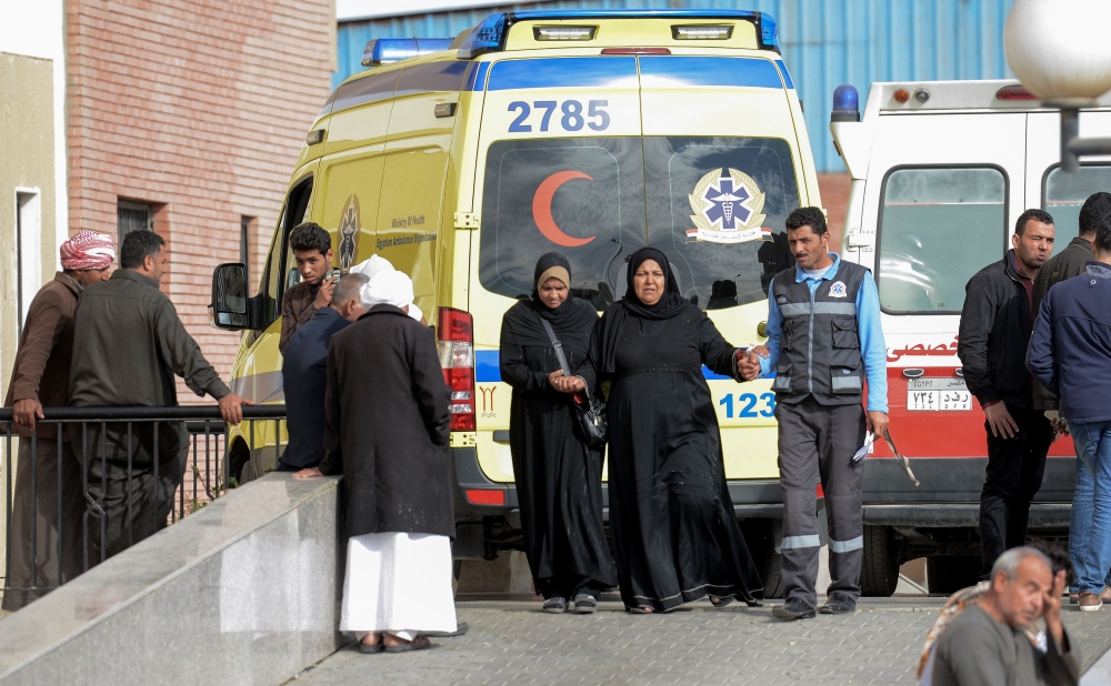 Relatives of the victims of the bomb and gun assault on the North Sinai Rawda mosque walk past an ambulance while waiting outside the Suez Canal University hospital in the eastern port city of Ismailia on November 25, 2017, where the injured were taken to receive treatment following the deadly attack the day before. Egypt's President Abdel Fattah al-Sisi vowed on November 24 to respond forcefully after the attackers killed at least 235 worshippers in the packed mosque in restive North Sinai province, the country's deadliest attack in recent memory. / AFP / MOHAMED EL-SHAHED
