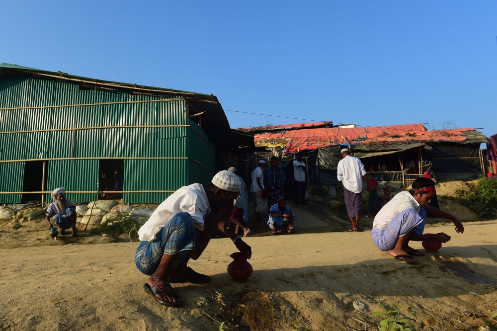 Rohingya Muslim refugees prepare to offer prayers in Tangkhali refugee camp in the Bangladeshi district of Ukhia on November 25, 2017. An estimated 618,000 Muslim Rohingya have fled mainly Buddhist Myanmar since a military crackdown was launched in Rakhine in August triggered an exodus, straining resources in the impoverished country. / AFP / Munir UZ ZAMAN
