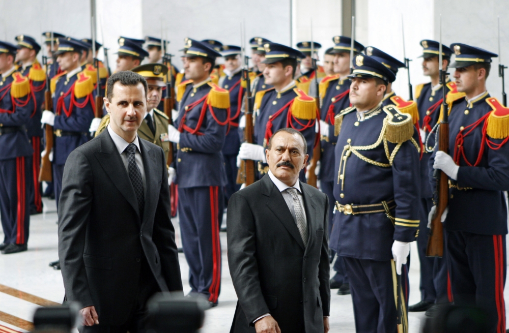 FILE  - In this Feb. 23, 2009 file photo, Syrian President Bashar Assad, left, and then Yemeni President, Ali Abdullah Saleh, review an honor guard at the al-Shaab presidential palace in Damascus, Syria. Saleh was killed Monday, Dec. 4, 2017, by Shiite rebels with whom he had once been allied. It was a grisly end for a leader who ruled for more than 30 years by shifting alliances and playing multiple sides in the many conflicts that plagued his impoverished nation. Even after his ouster in 2012, he remained a power player driving the civil war that has brought Yemen to ruinous collapse. (AP Photo/Bassem Tellawi, File)