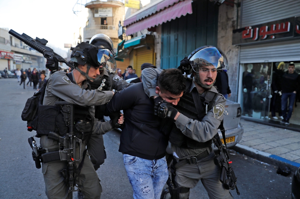 Israeli security forces detain a Palestinian protester on December 9, 2017, in East Jerusalem. Retaliatory Israeli air strikes on the Gaza Strip killed two Hamas militants, as unrest simmered across the Palestinian territories over US President Donald Trump's declaration of Jerusalem as Israel's capital. / AFP / Ahmad GHARABLI
