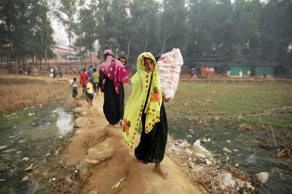 Rohingya refugees walk through the Kutupalong refugee camp near Cox's Bazar, Bangladesh December 19, 2017. REUTERS/Marko Djurica