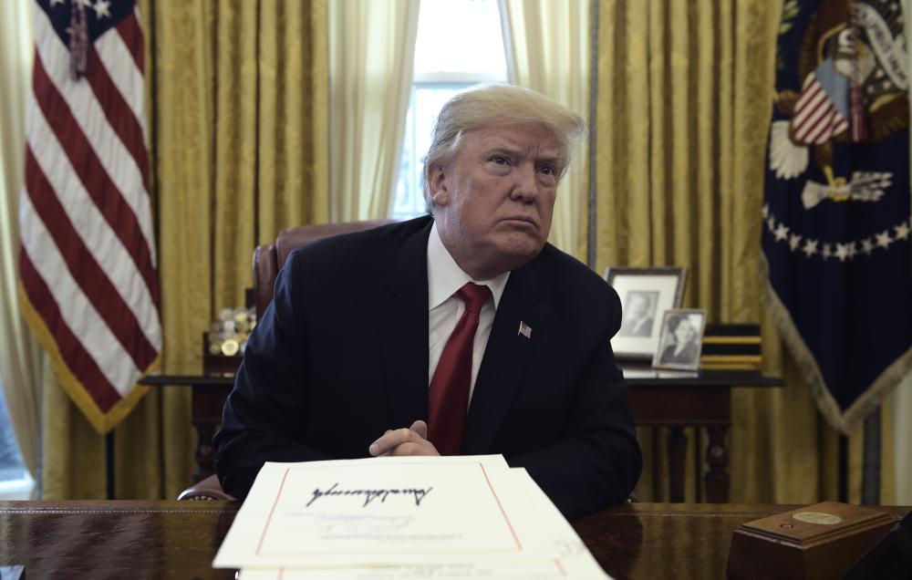 United States President Donald J. Trump during an event to sign the Tax Cut and Reform Bill in the Oval Office at The White House in Washington, DC on December 22, 2017.  / AFP / Brendan SMIALOWSKI
