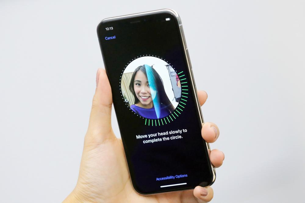 An attendee uses the Face ID function on the new iPhone X during a presentation for the media in Beijing, China October 31, 2017. REUTERS/Thomas Peter - RC1909DB4F00