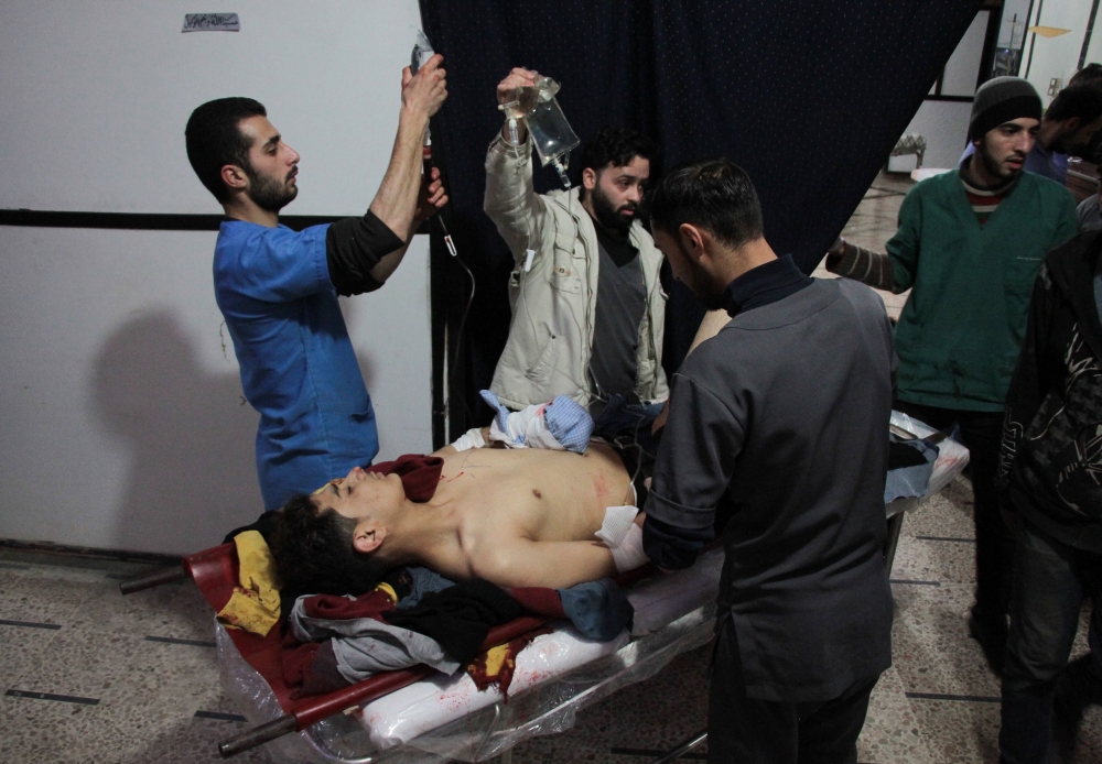 A Syrian youth receives treatment at a makeshift clinic following a reported strike by Syrian government forces in the rebel-held town of Douma, in Syria's eastern Ghouta region, on January 2, 2018.  / AFP / Hamza Al-Ajweh
