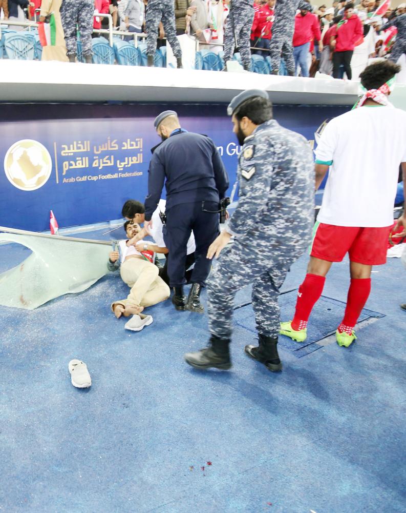 A wounded fan awaits treatment after a glass barrier broke at the end of the Gulf Cup of Nations 2017 final football match between Oman and the UAE at the Sheikh Jaber al-Ahmad Stadium in Kuwait City on January 5, 2018.  / AFP / Yasser Al-Zayyat
