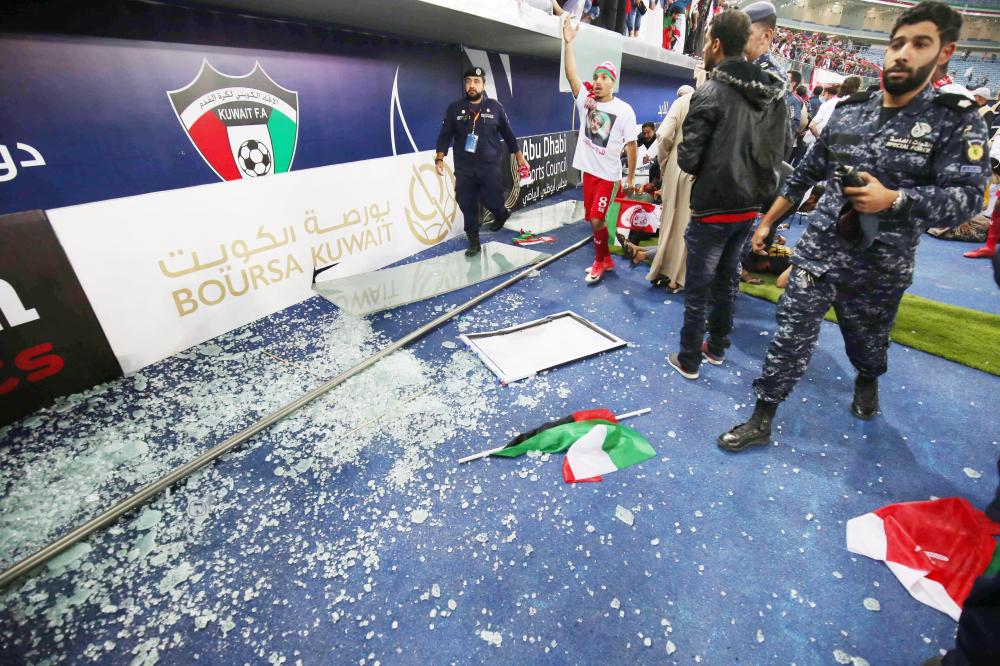 The remains of a glass barrier are seen on the ground after the barrier broke at the end of the Gulf Cup of Nations 2017 final football match between Oman and the UAE at the Sheikh Jaber al-Ahmad Stadium in Kuwait City on January 5, 2018.  / AFP / Yasser Al-Zayyat
