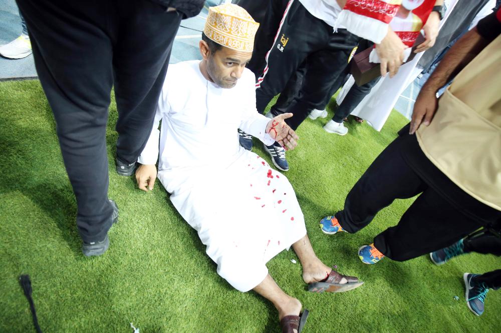 A wounded fan awaits treatment after a glass barrier broke at the end of the Gulf Cup of Nations 2017 final football match between Oman and the UAE at the Sheikh Jaber al-Ahmad Stadium in Kuwait City on January 5, 2018.  / AFP / Yasser Al-Zayyat
