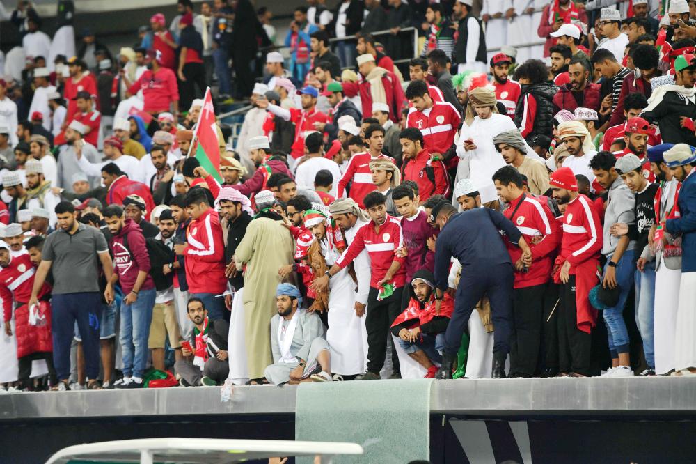 Omani fans stand behind a broken glass barrier at the end of the Gulf Cup of Nations 2017 final football match between Oman and the UAE at the Sheikh Jaber al-Ahmad Stadium in Kuwait City on January 5, 2018.  / AFP / GIUSEPPE CACACE
