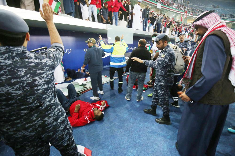 Wounded fans await treatment after a glass barrier broke at the end of the Gulf Cup of Nations 2017 final football match between Oman and the UAE at the Sheikh Jaber al-Ahmad Stadium in Kuwait City on January 5, 2018.  / AFP / Yasser Al-Zayyat
