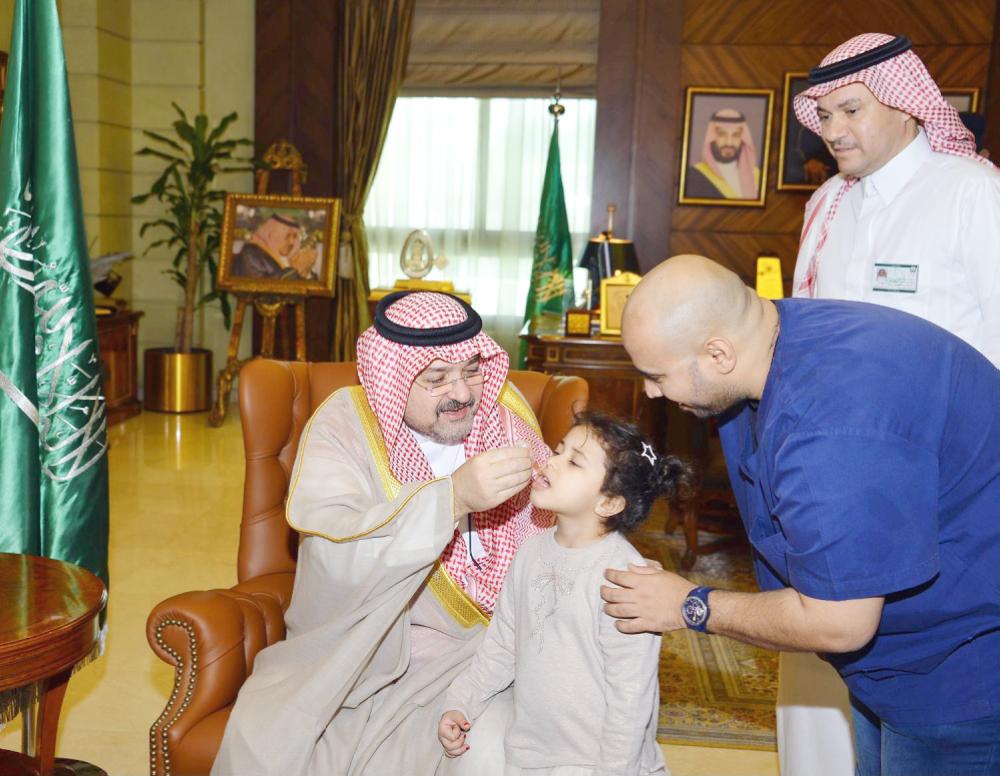 



الأمير مشعل بن ماجد يطعم طفلة ضد مرض شلل الأطفال. (عكاظ)