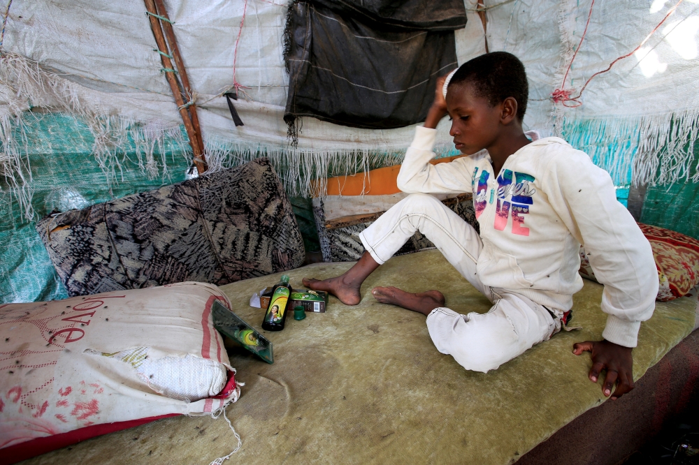 Ayoub Mohammed Ruzaiq, 11, combs his hair inside his family's hut next to a garbage dump where he collects recyclables and food near the Red Sea port city of Hodeidah, Yemen, January 16, 2018. 