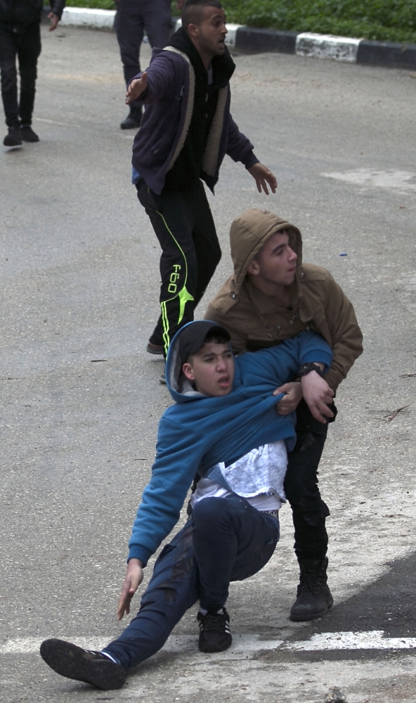 Palestinian youths evacuate a wounded comrade during clashes with Israeli forces in Jenin, in the north of the occupied West Bank, on January 18, 2018. A Palestinian was killed during clashes with Israeli forces in Jenin, the Palestinian health ministry announced. Israel's Shin Beth security services said shots were fired during a raid by border guards to capture the alleged perpetrators of an attack earlier this month in which a rabbi was shot dead.
 / AFP / JAAFAR ASHTIYEH
