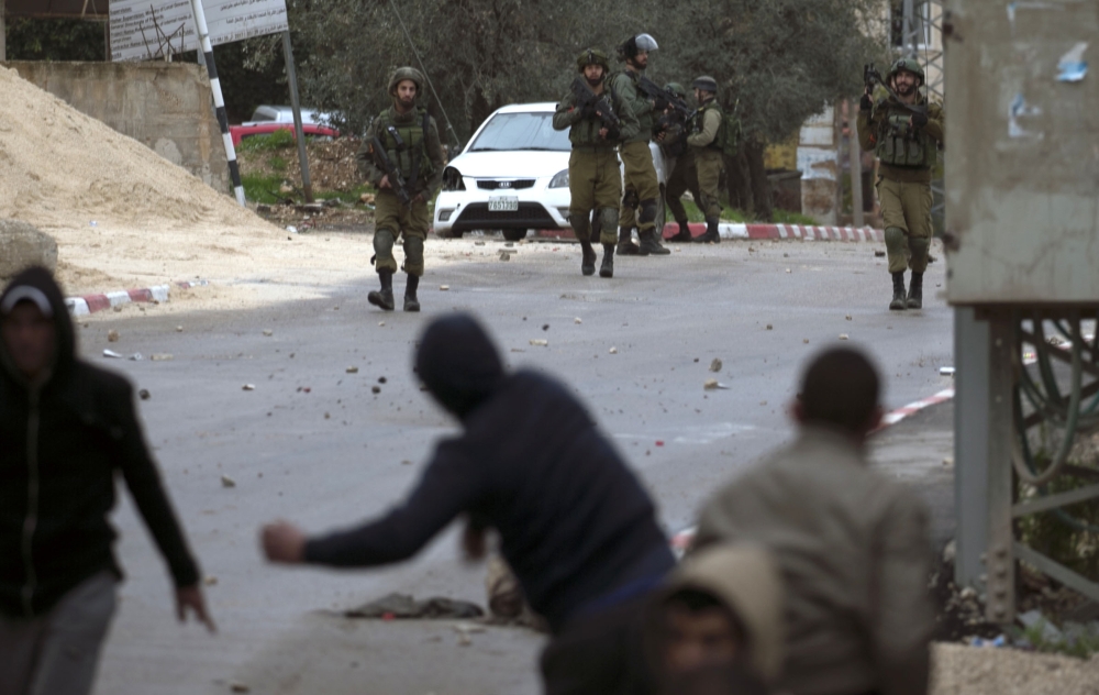 Israeli forces clash with Palestinian youths during a military operation in Jenin, in the north of the occupied West Bank, on January 18, 2018.  A Palestinian was killed during clashes with Israeli forces in Jenin, the Palestinian health ministry announced. Israel's Shin Beth security services said shots were fired during a raid by border guards to capture the alleged perpetrators of an attack earlier this month in which a rabbi was shot dead.
 / AFP / JAAFAR ASHTIYEH

