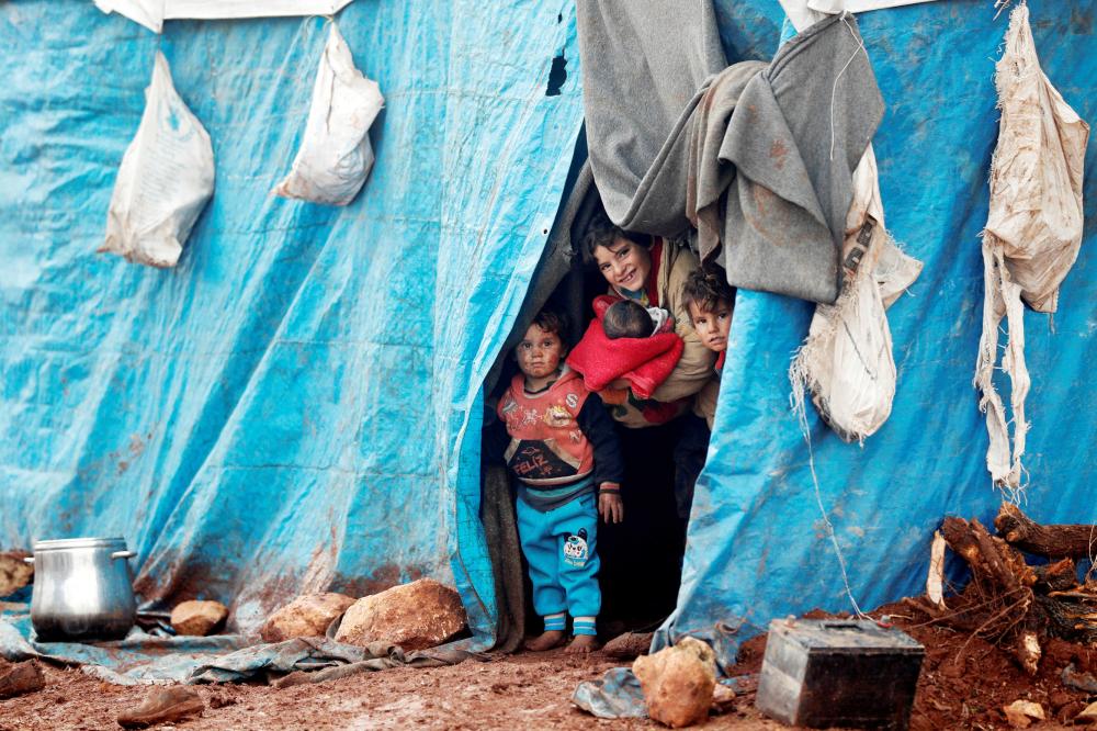 Displaced Syrian children look out from their tents at Kelbit refugee camp, near the Syrian-Turkish border, in Idlib province, Syria January 17, 2018. Picture taken January 17, 2018. REUTERS/Osman Orsal     TPX IMAGES OF THE DAY