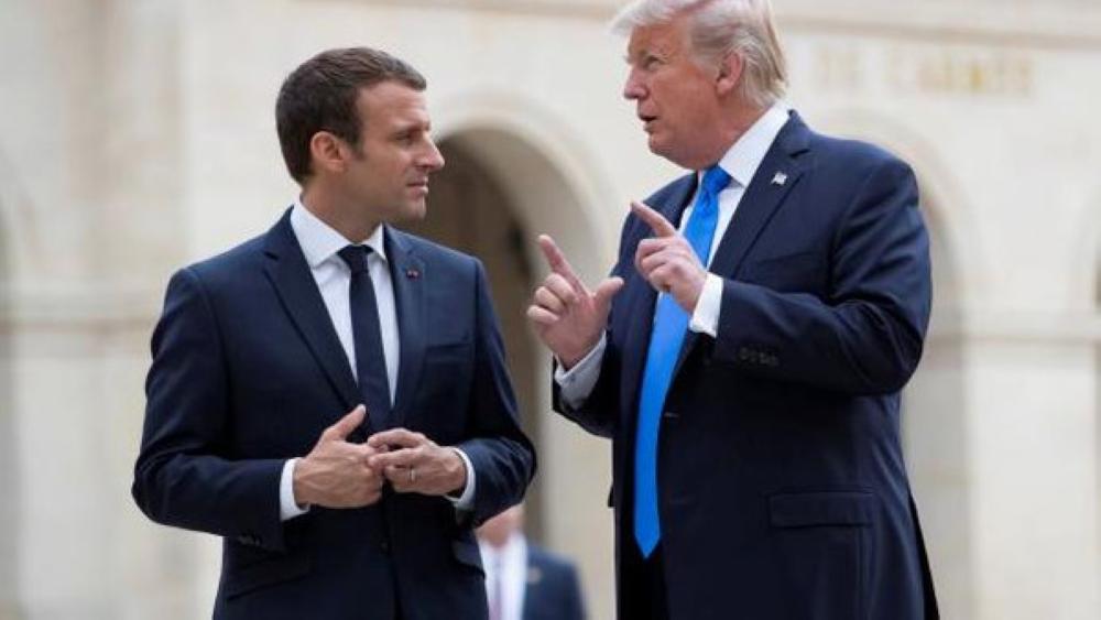 French President Emmanuel Macron (L) and U.S. President Donald Trump (R) speak as they leave Les Invalides museum in Paris, France, July 13, 2017.  REUTERS/Ian Langsdon/Pool