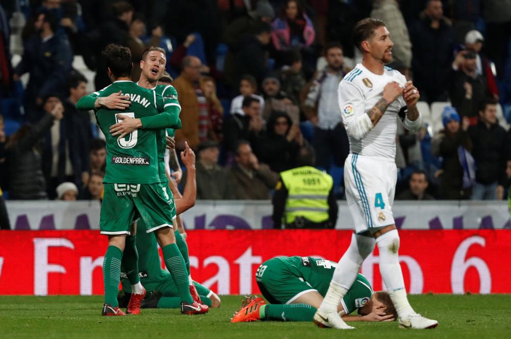 Soccer Football - Spanish King's Cup - Real Madrid vs Leganes - Quarter Final Second Leg - Santiago Bernabeu, Madrid, Spain - January 24, 2018   Leganes celebrate as Real Madrid’s Sergio Ramos looks dejected after the match          REUTERS/Juan Medina