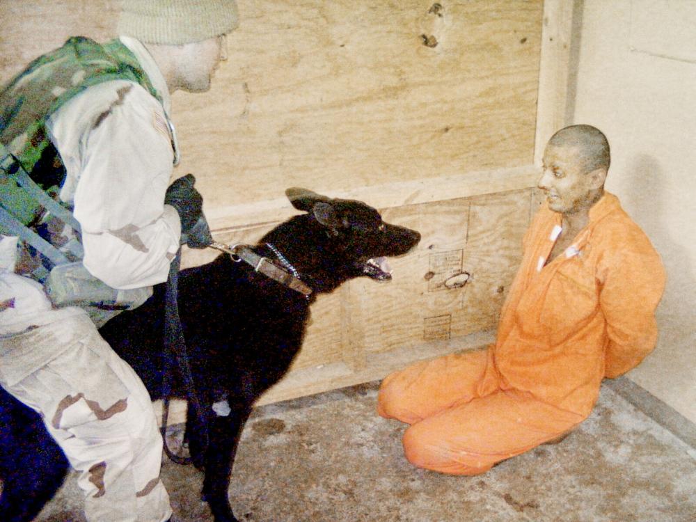 **MANDATORY CREDIT TO THE WASHINGTON POST** In this undated still photo released 21 May 2004, an Iraqi detainee at Abu Ghraib Prison, in Baghdad, appears to be intimidated by a US soldier using an trained dog. AFP PHOTO /**MANDATORY CREDIT TO THE WASHINGTON POST**INTERNET OUT**NO SALES**