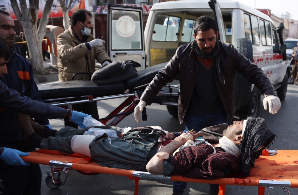 People help carry an injured man to the hospital following a suicide attack in Kabul, Afghanistan, Saturday Jan. 27, 2018. Authorities say suicide car bomber killed dozens of people and wounded over 100 in an attack claimed by the Taliban in the Afghan capital Kabul, authorities said. (AP Photo/ Rahmat Gul)