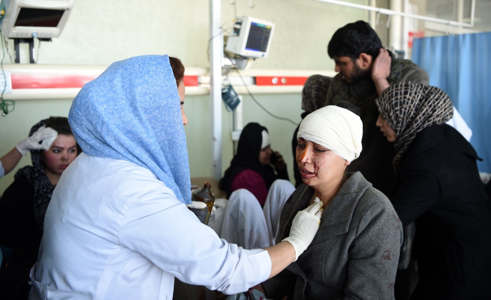 TOPSHOT - Afghan medical staff treat a wounded women, after a car bomb exploded near the old Interior Ministry building, at Jamhuriat Hospital in Kabul on January 27, 2018. An ambulance packed with explosives blew up in a crowded area of Kabul on January 27, killing at least 17 people and wounding 110 others, officials said, in an attack claimed by the Taliban.
 / AFP / WAKIL KOHSAR
