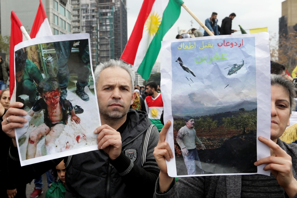 Lebanese Kurds wave flags and chant slogans on January 28, 2018, during a protest near the European Commission offices in Beirut against the ongoing Turkish military campaign in the Kurdish-held Syrian enclave of Afrin. Turkey launched an offensive against the Kurdish People's Protection Units (YPG) on January 20 in their enclave of Afrin, supporting Syrian rebels with air strikes and ground troops. / AFP / ANWAR AMRO
