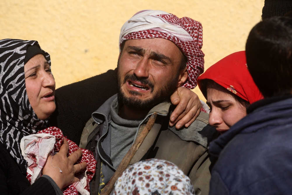 Relatives of a Kurdish herder mourn outside the hospital in Afrin on January 28, 2018, after he was killed in a Turkish airstrike on their village near the Kurdish enclave. Turkey launched operation «Olive Branch» on January 20 against the Syrian Kurdish People's Protection Units (YPG) militia in Afrin, supporting Syrian opposition fighters with ground troops and air strikes. / AFP / DELIL SOULEIMAN
