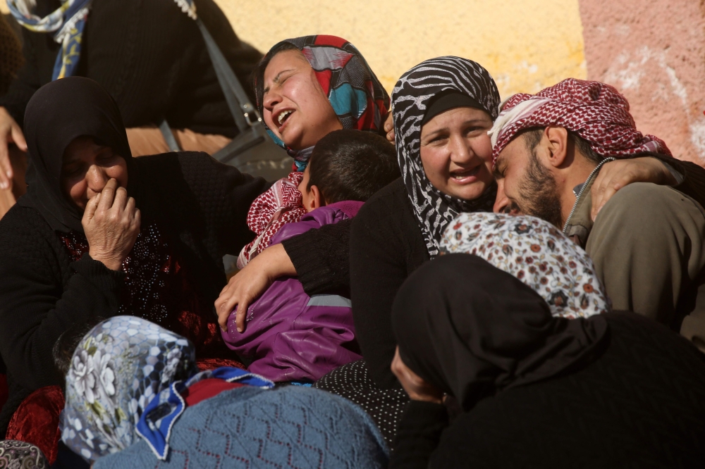 Relatives of a Kurdish herder mourn outside the hospital in Afrin on January 28, 2018, after he was killed in a Turkish airstrike on their village near the Kurdish enclave. Turkey launched operation «Olive Branch» on January 20 against the Syrian Kurdish People's Protection Units (YPG) militia in Afrin, supporting Syrian opposition fighters with ground troops and air strikes. / AFP / DELIL SOULEIMAN
