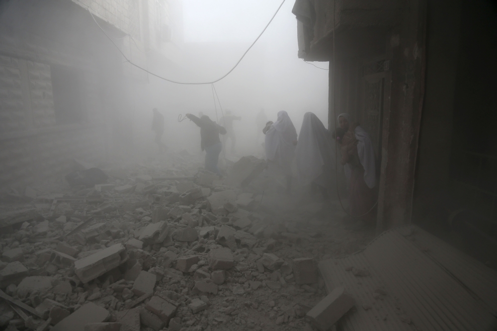 TOPSHOT - Syrian flee their homes following an airstrike in the rebel-held besieged town of Arbin, in the eastern Ghouta region on the outskirts of the capital Damascus on February 2, 2018. / AFP / ABDULMONAM EASSA
