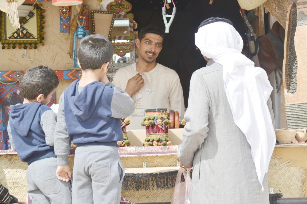 



زوار القرية الشعبية يطلعون على منتجات التطريز.