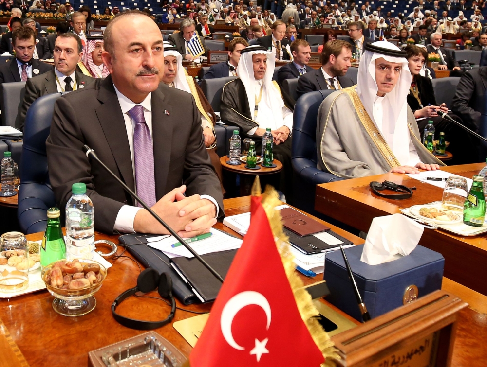 Turkish Foreign Minister Mevlut Cavusoglu (L) and Saudi Foreign Minister Adel al-Jubeir attend the second day of an international conference for reconstruction of Iraq, in Kuwait City, on February 14, 2018. / AFP / YASSER AL-ZAYYAT
