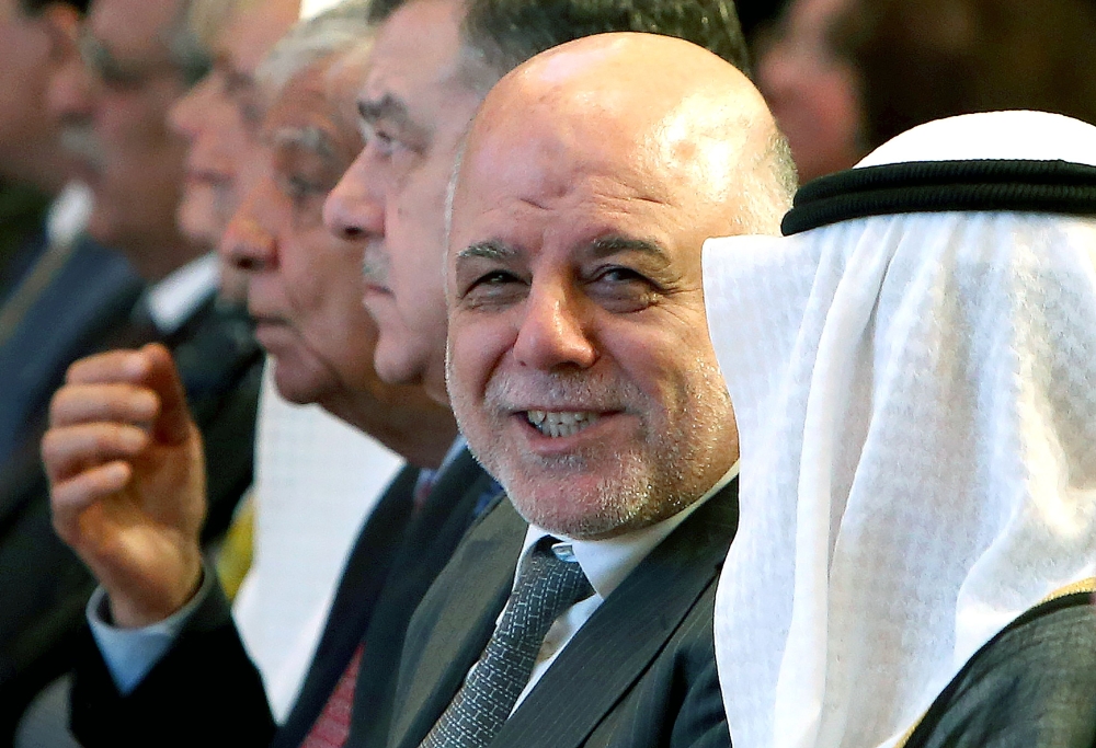 CORRECTION / Iraqi Prime Minister Haider al-Abadi (C) looks on during the Kuwait international conference for the reconstruction of Iraq in Kuwait City on February 13, 2018. / AFP / YASSER AL-ZAYYAT
