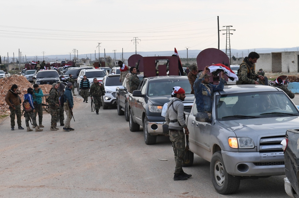 CORRECTION / A picture taken on February 20, 2018 shows a convoy of pro-Syrian government fighters arriving in Syria's northern region of Afrin. Kurdish forces said in a statement on February 20 that pro-regime fighters deployed to Syria's Afrin region will take up positions and «participate in defending the territorial unity of Syria and its borders», countering Turkey's offensive on the area. / AFP / George OURFALIAN
