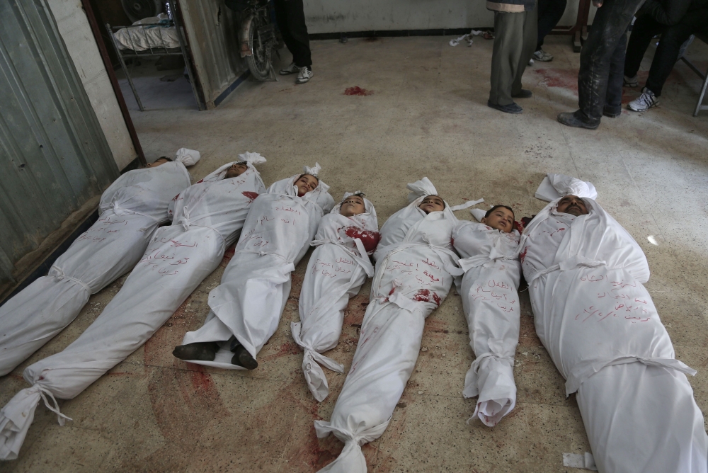 A picture taken on February 20, 2018 shows bodies of Syrian civilian victims prepared for burial after they were killed during reported regime air strikes in the rebel-held town of Arbin, in the besieged Eastern Ghouta region on the outskirts of the capital Damascus. / AFP / ABDULMONAM EASSA
