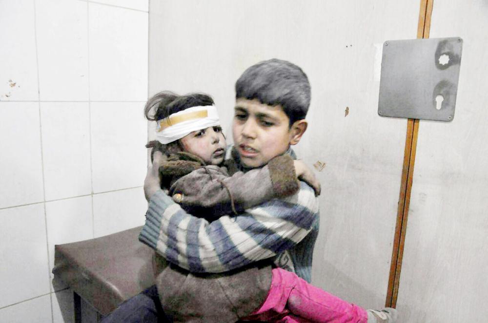 This photo released on Wednesday Feb. 21, 2018 provided by the Syrian anti-government activist group Ghouta Media Center, which has been authenticated based on its contents and other AP reporting, shows two Syrian kids who were wounded during airstrikes and shelling by Syrian government forces, sit at a makeshift hospital, in Ghouta, suburb of Damascus, Syria. New airstrikes and shelling on the besieged, rebel-held suburbs of the Syrian capital killed at least 10 people on Wednesday, a rescue organization and a monitoring group said. (Ghouta Media Center via AP)