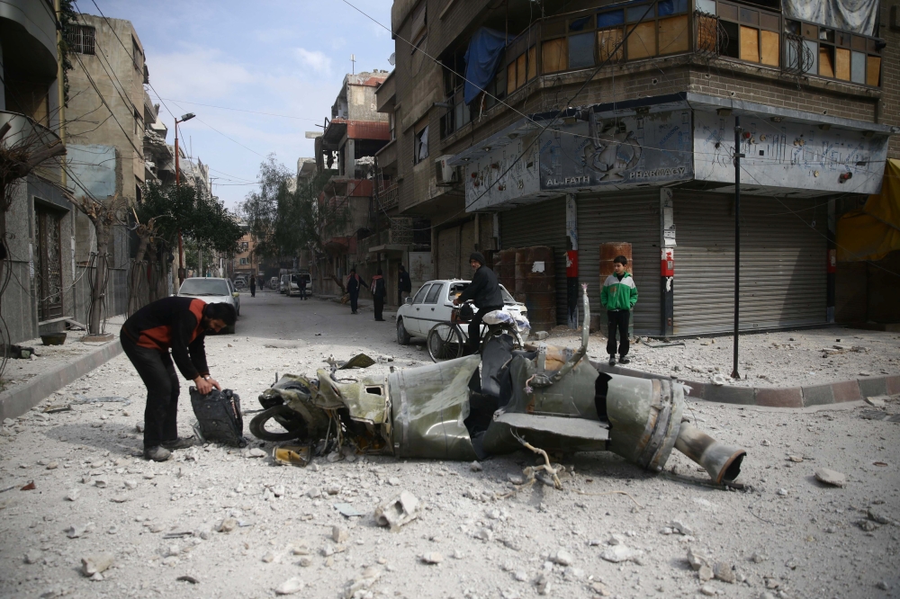 People inspect missile remains in the besieged town of Douma, in eastern Ghouta, in Damascus, Syria, February 23, 2018. REUTERS/Bassam Khabieh