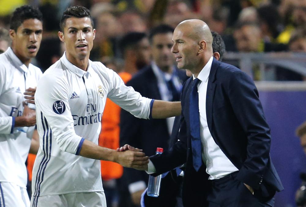 Real Madrid's Cristiano Ronaldo celebrates scoring the opening goal with Real Madrid's head coach Zinedine Zidane during the Champions League group F soccer match between Borussia Dortmund and Real Madrid in Dortmund, Germany, Tuesday, Sept. 27, 2016. (AP Photo/Michael Probst)