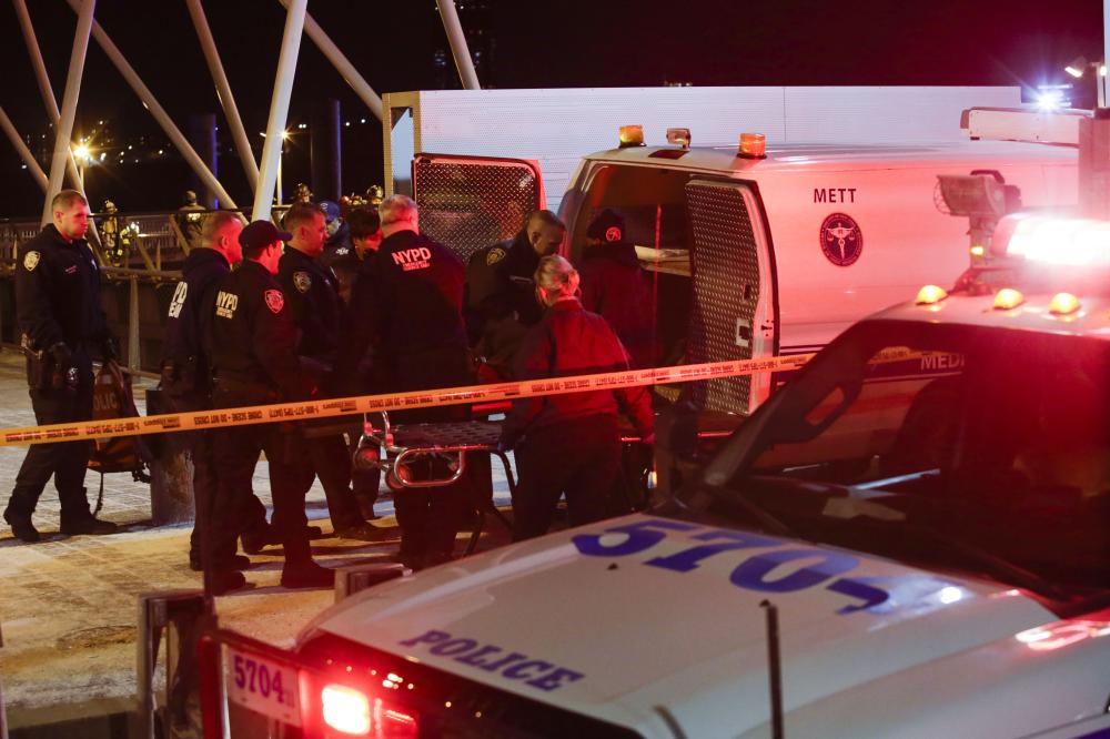 NEW YORK, NY - MARCH 11: NYPD officers remove the bodies from the scene of a helicopter crash in the East River on March 11, 2018 in New York City. According to reports, two people died another three people are in critical condition.   Eduardo Munoz Alvarez/Getty Images/AFP
== FOR NEWSPAPERS, INTERNET, TELCOS & TELEVISION USE ONLY ==
