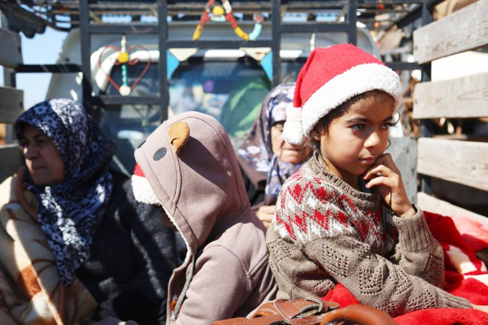 Syrians wait at a check point in the village of Anab ahead of crossing to the Turkish-backed Syrian rebels side on March 17, 2018, as civilians flee the city of Afrin in northern Syria. More than 200,000 civilians have fled the city of Afrin in northern Syria in less than three days to escape a Turkish-led military offensive against a Kurdish militia, the Syrian Observatory for Human Rights said. / AFP / Nazeer al-Khatib
