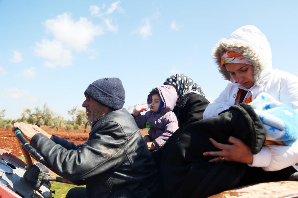 Syrians wait at a check point in the village of Anab ahead of crossing to the Turkish-backed Syrian rebels side on March 17, 2018, as civilians flee the city of Afrin in northern Syria. More than 200,000 civilians have fled the city of Afrin in northern Syria in less than three days to escape a Turkish-led military offensive against a Kurdish militia, the Syrian Observatory for Human Rights said. / AFP / Nazeer al-Khatib
