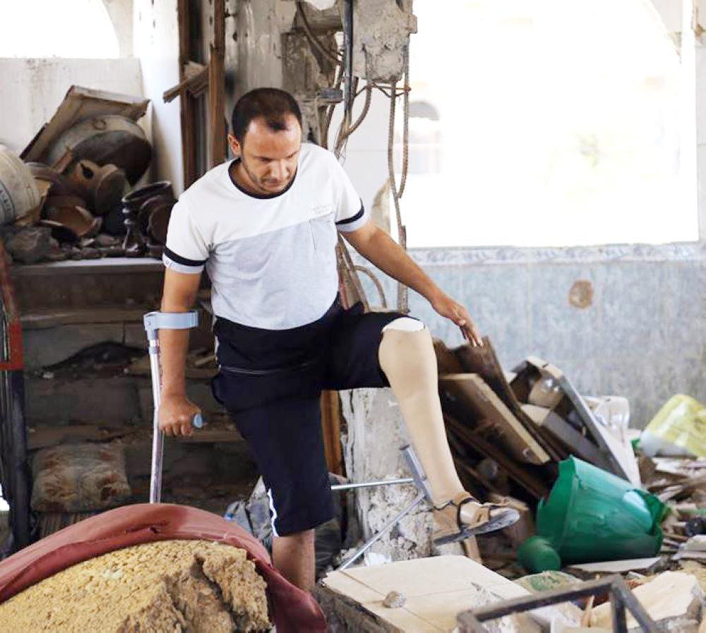 



يمني فقد ساقه يتفقد منزله الذي دمرته ميليشيا الحوثي في تعز.  (أحمد الباشا) 