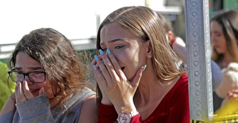 Students released from a lockdown are overcome with emotion following following a shooting at Marjory Stoneman Douglas High School in Parkland, Fla., Wednesday, Feb. 14, 2018. (John McCall/South Florida Sun-Sentinel via AP)