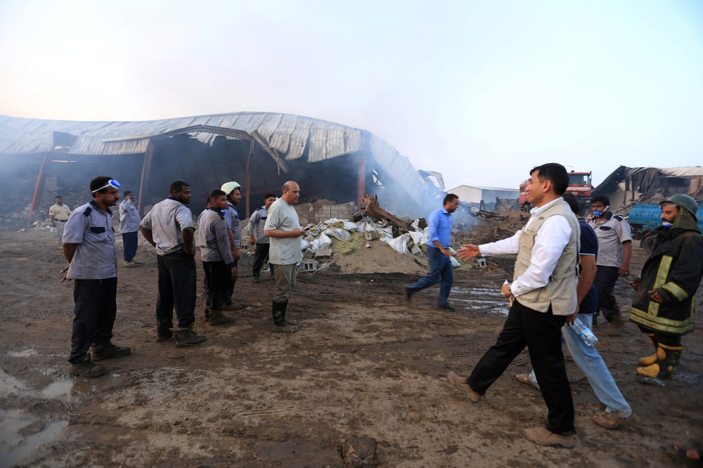 Aid workers inspect warehouses of the World Food Programme a day after fire engulfed them in the Red Sea port city of Hodeida, Yemen April 1, 2018. REUTERS/Abduljabbar Zeyad