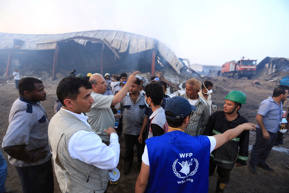 Aid workers inspect a World Food Programme warehouse a day after fire engulfed it in the Red Sea port city of Hodeida, Yemen April 1, 2018. REUTERS/Abduljabbar Zeyad