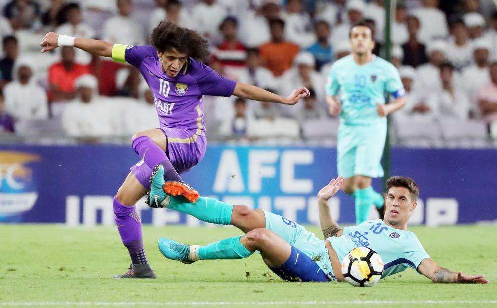 Al-Ain's midfielder and captain Omar Abdulrahman (L) vies for the ball with al-Hilal's midfielder Nicolas Milesi during the AFC Champions League match between UAE's al-Sadd and Saudi's al-Hilal at the Hazza bin Zayed Stadium in Al-Ain, on April 2, 2018. / AFP / KARIM SAHIB
