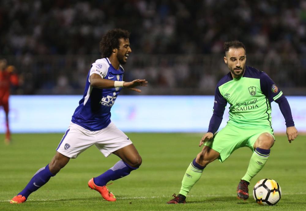 اليوناني فيتفا لاعب الأهلي يحاول المرور من المدافع الهلالي ياسر الشهراني