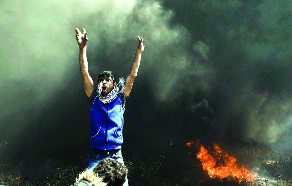 A Palestinian demonstrator shouts during clashes with Israeli troops at a protest demanding the right to return to their homeland, at the Israel-Gaza border east of Gaza City April 6, 2018. REUTERS/Mohammed Salem